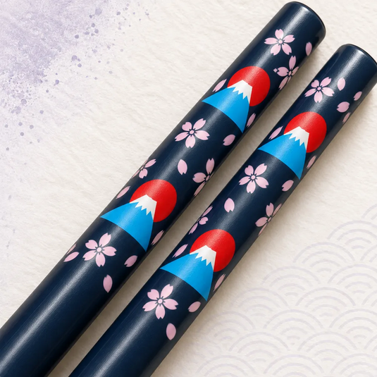 Très gros plan des monts Fuji bleus à sommet blanc, des soleils rouges et des fleurs roses imprimés sur les baguettes japonaises Fuji-San Ao.