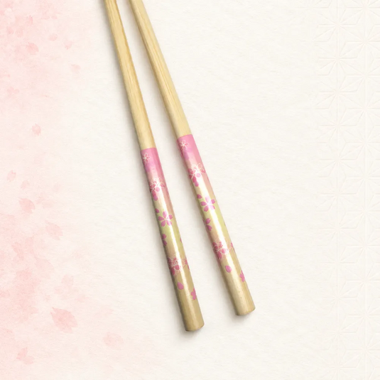 Paire de baguettes japonaises Sakurairo en bambou clair, décorées de fleurs de cerisier roses. Vue rapprochée.