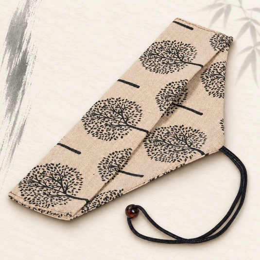 Étui à baguettes en coton et lin écru à motif d’arbres noirs Ki, avec lien de fermeture.