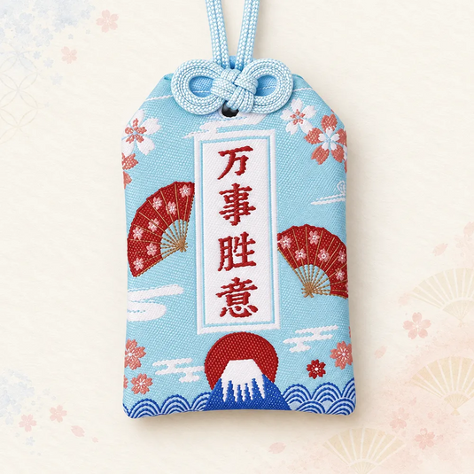 Omamori japonais bleu aqua pâle, brodé du mont Fuji, d’éventails rouges et de fleurs de cerisier.