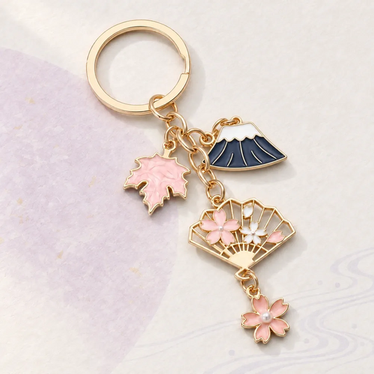 Porte-clés japonais doré avec mont Fuji bleu marine, éventail fleuri, feuille d’érable et fleurs de sakura roses.