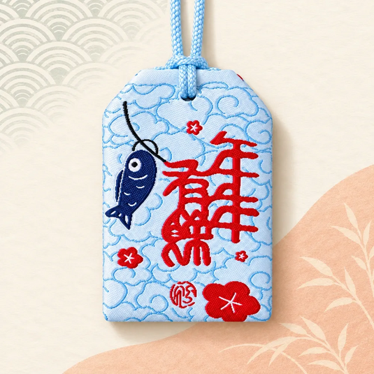 Verso de l’amulette porte-bonheur chat et carpes koï, avec motif rouge brodé sur fond bleu clair.