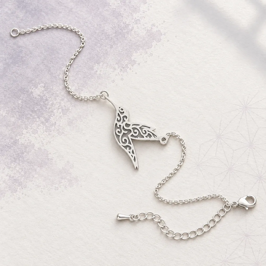 Bracelet japonais argenté avec colibri ajouré, chaîne fine et fermoir réglable.