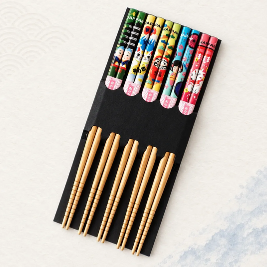 Lot de cinq paires de baguettes japonaises en bambou, avec motifs Japan colorés et support noir.