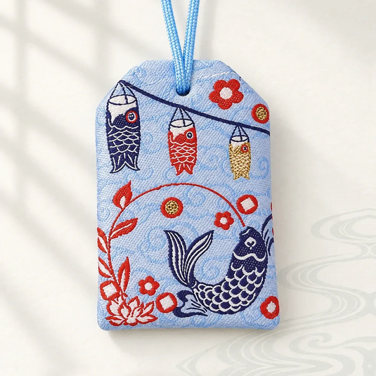 Verso de l’omamori japonais bleu clair, brodé d’une carpe koï bleu marine et de motifs rouges.