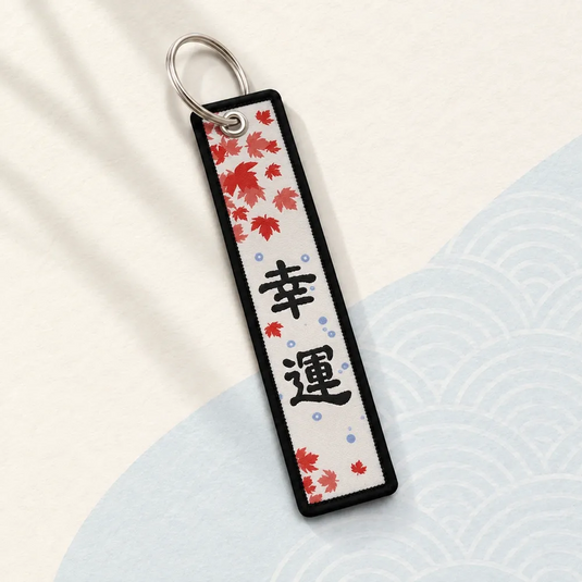 Verso du porte-clés japonais Carpe Koï, avec caractères noirs, feuilles d’érable rouges et anneau argenté.