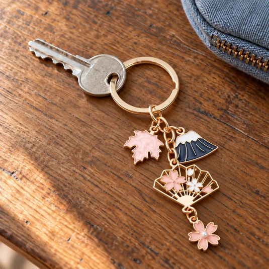 Porte-clés japonais Mont Fuji et Sakura relié à une clé, posé sur une table en bois.